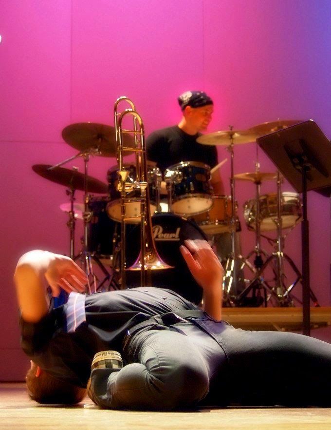 Dr. Shuey on drum set with a trombonist and a dancer