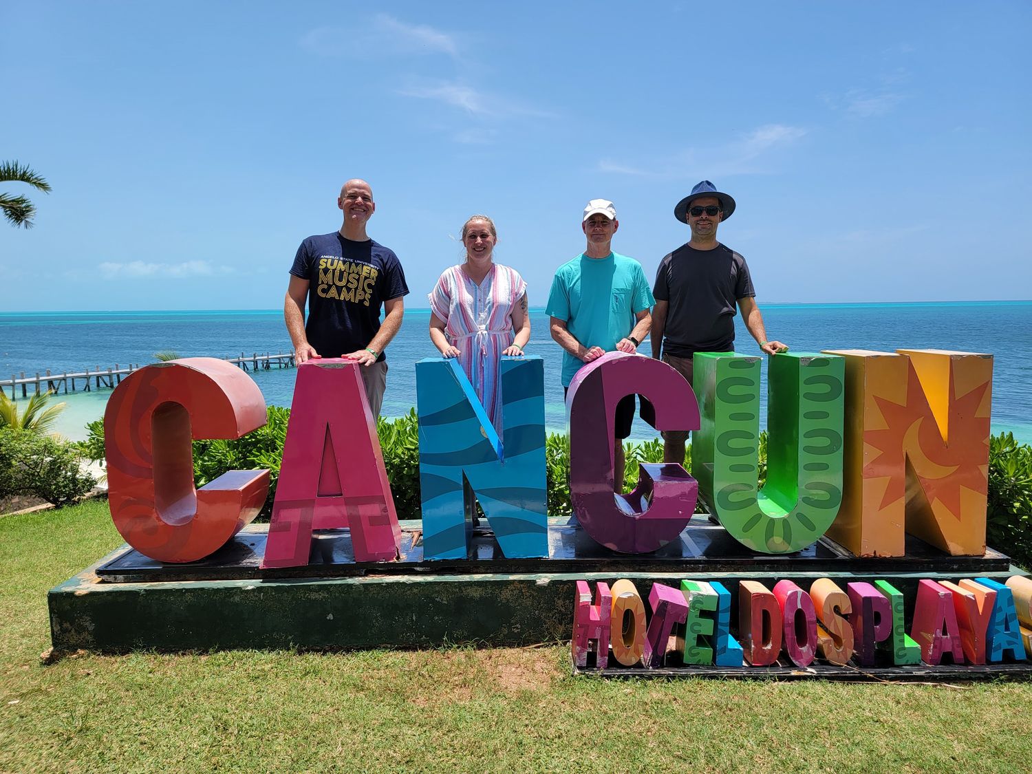 Musicians at the Cancún sign, 2021