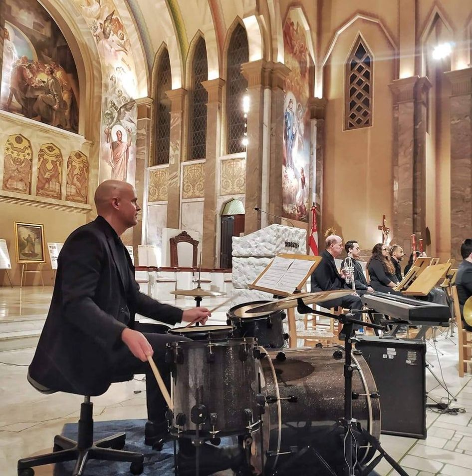 Dr. Shuey playing drum set in a church