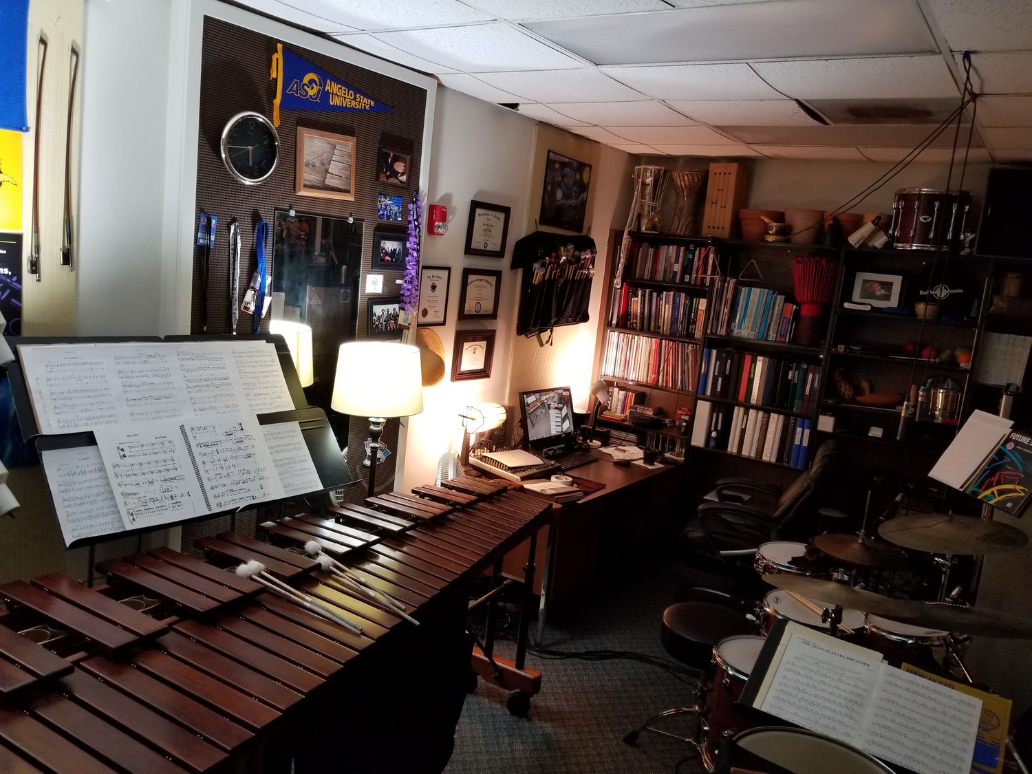 A teaching studio with a marimba, drums, and shelves of music