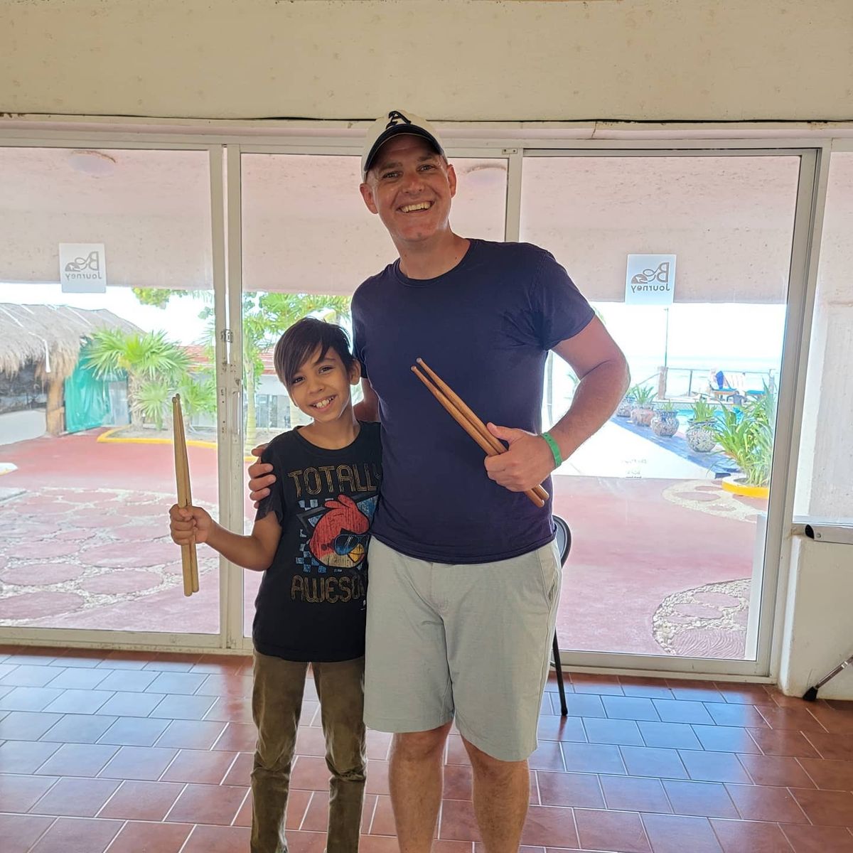 Dr. Shuey with a young drummer, both holding drumsticks